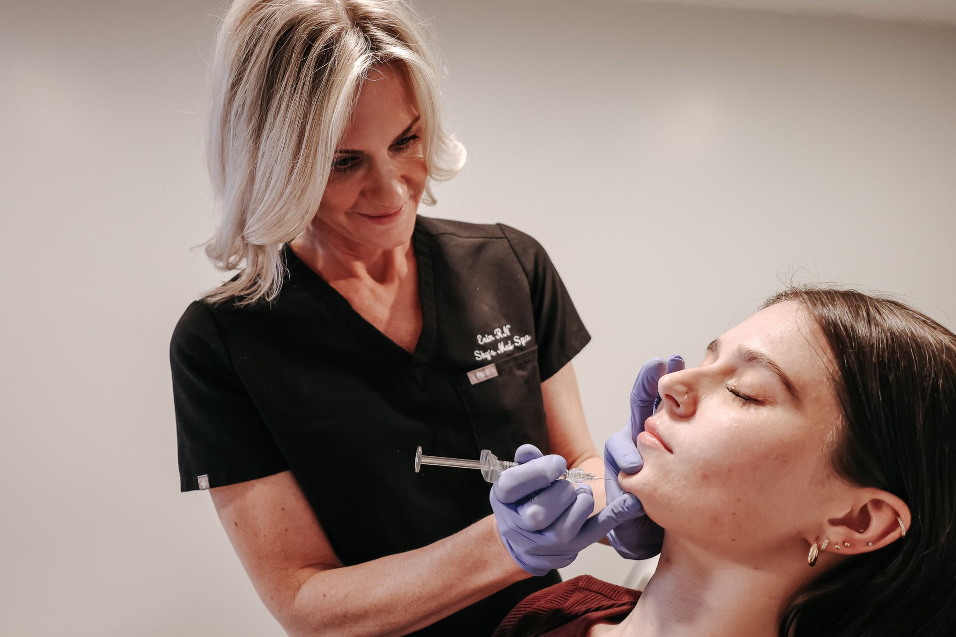 A woman is getting a botox injection in her face.