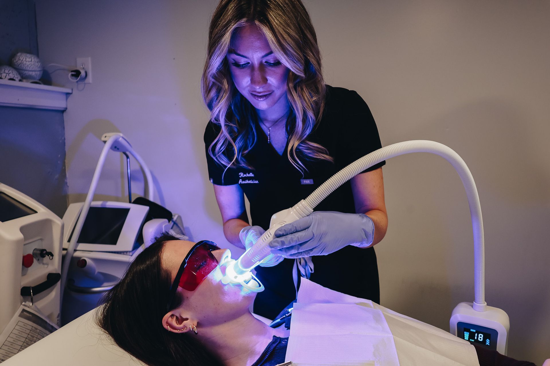 A woman is getting her teeth whitened by a dentist.