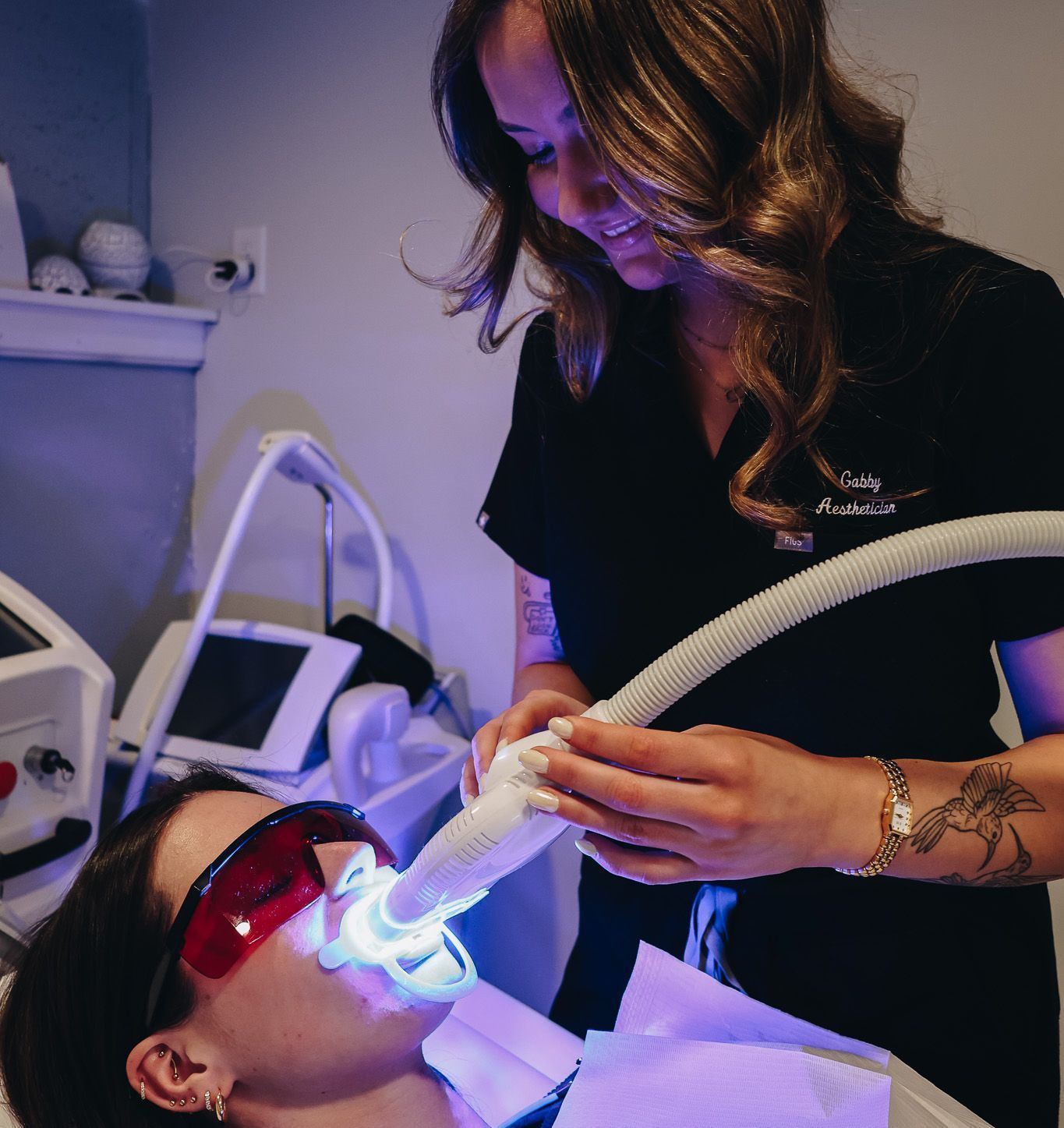 A woman is getting her teeth whitened by a dentist.