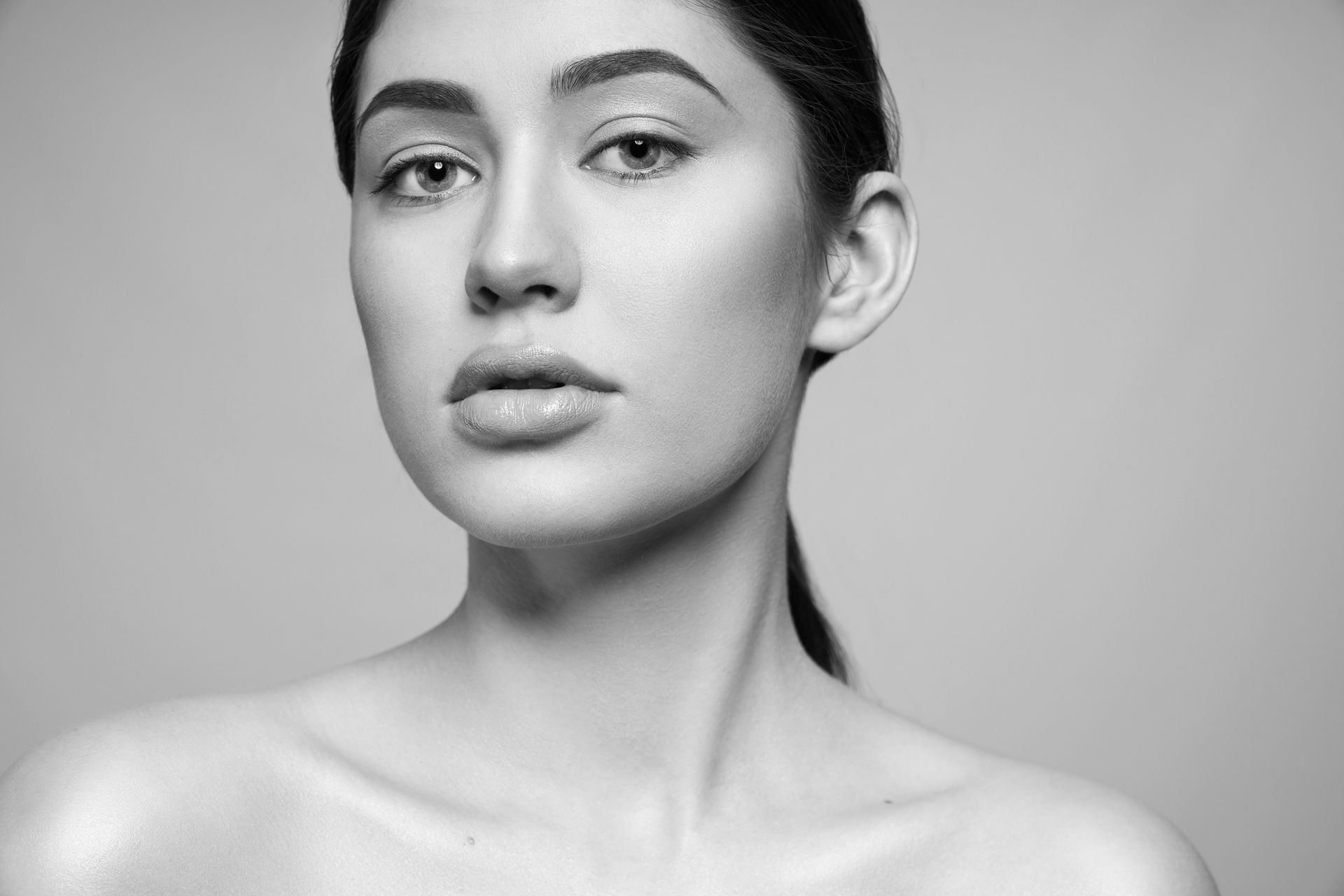 A black and white photo of a woman 's face and neck.