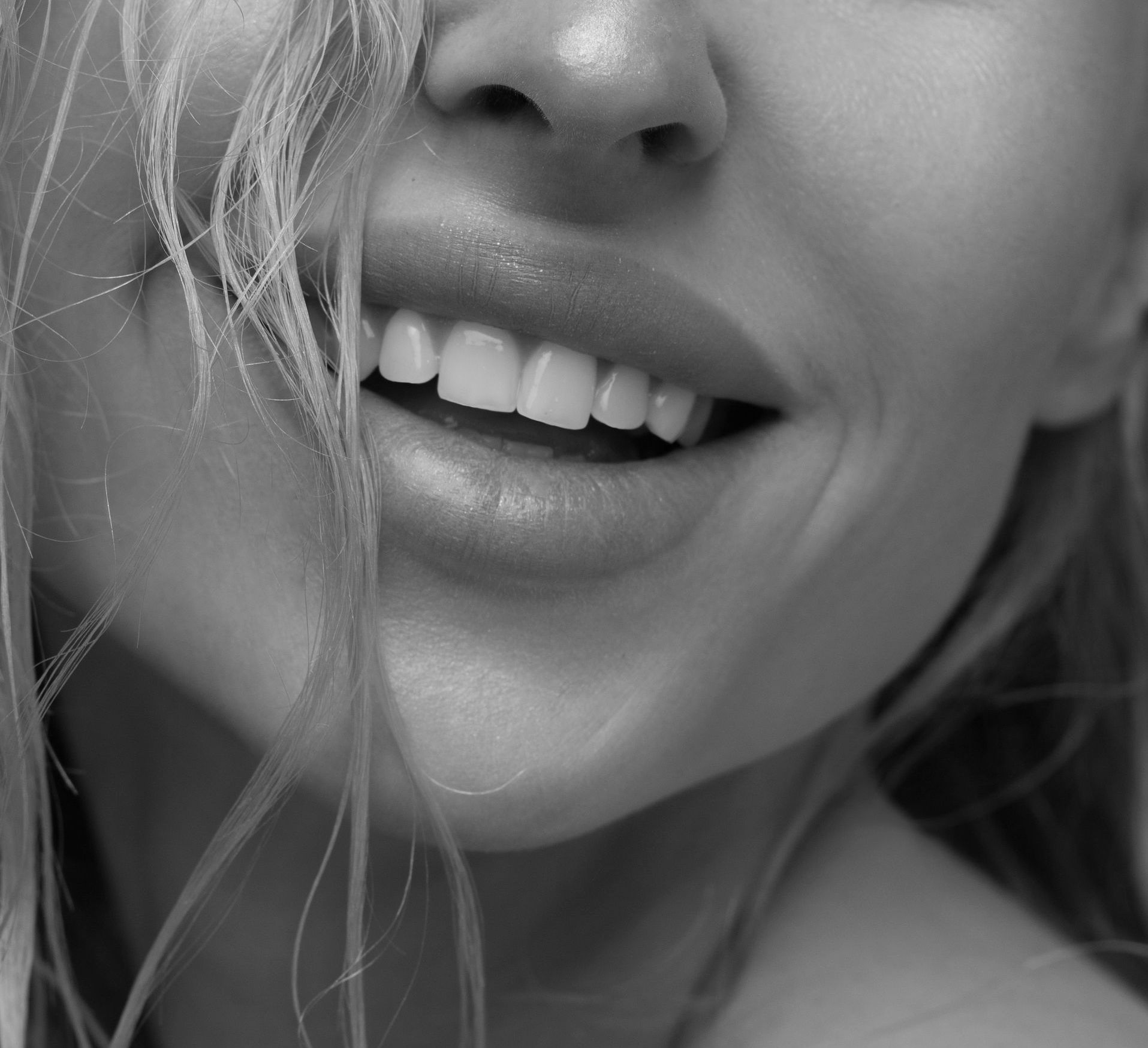 A close up of a woman 's mouth and teeth in a black and white photo.