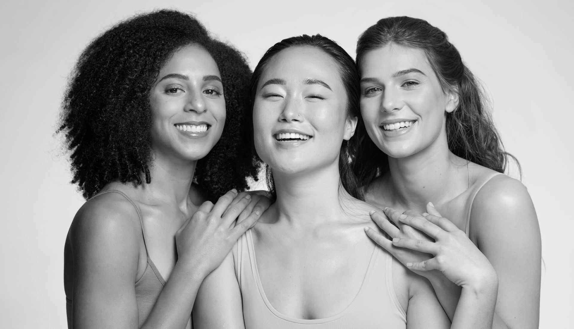 Three women are posing for a picture together in a black and white photo.