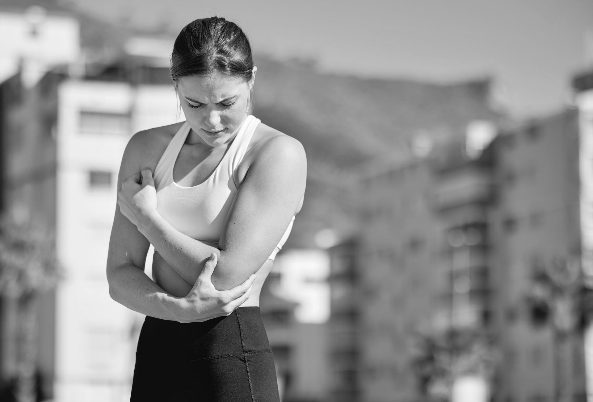 A woman is holding her elbow in pain.