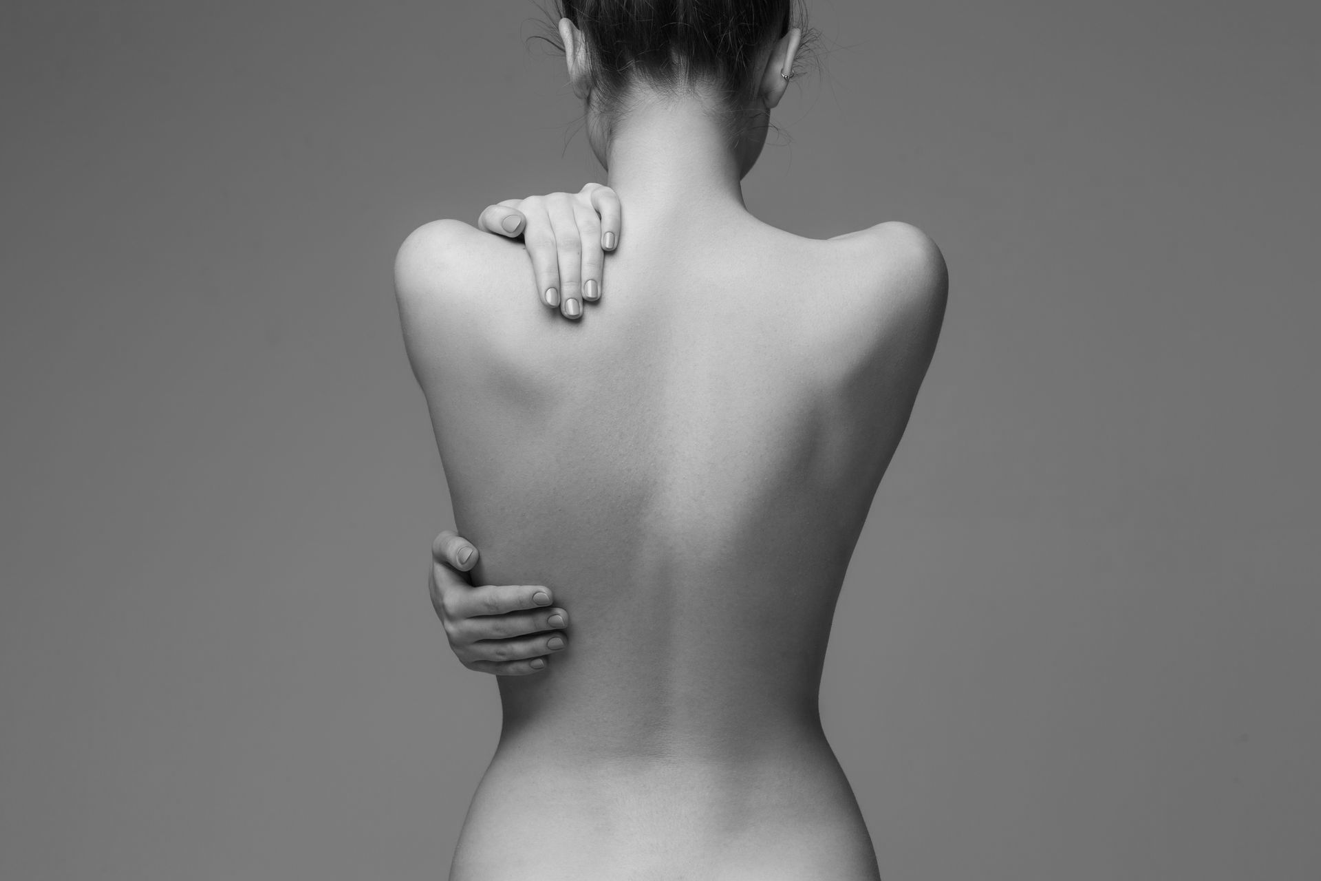 It is a black and white photo of a woman 's back.