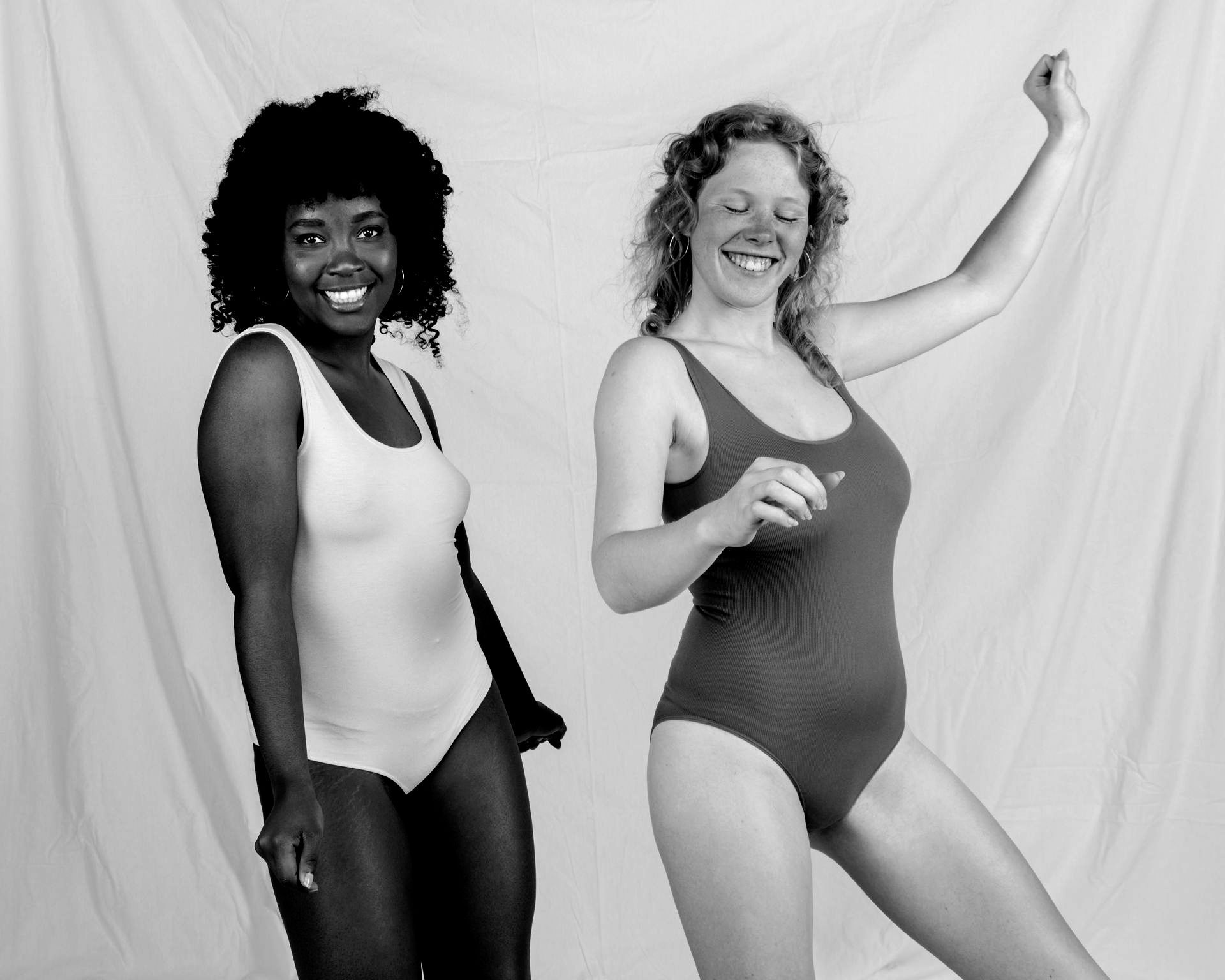 A woman is standing with her hands on her hips in a black and white photo.