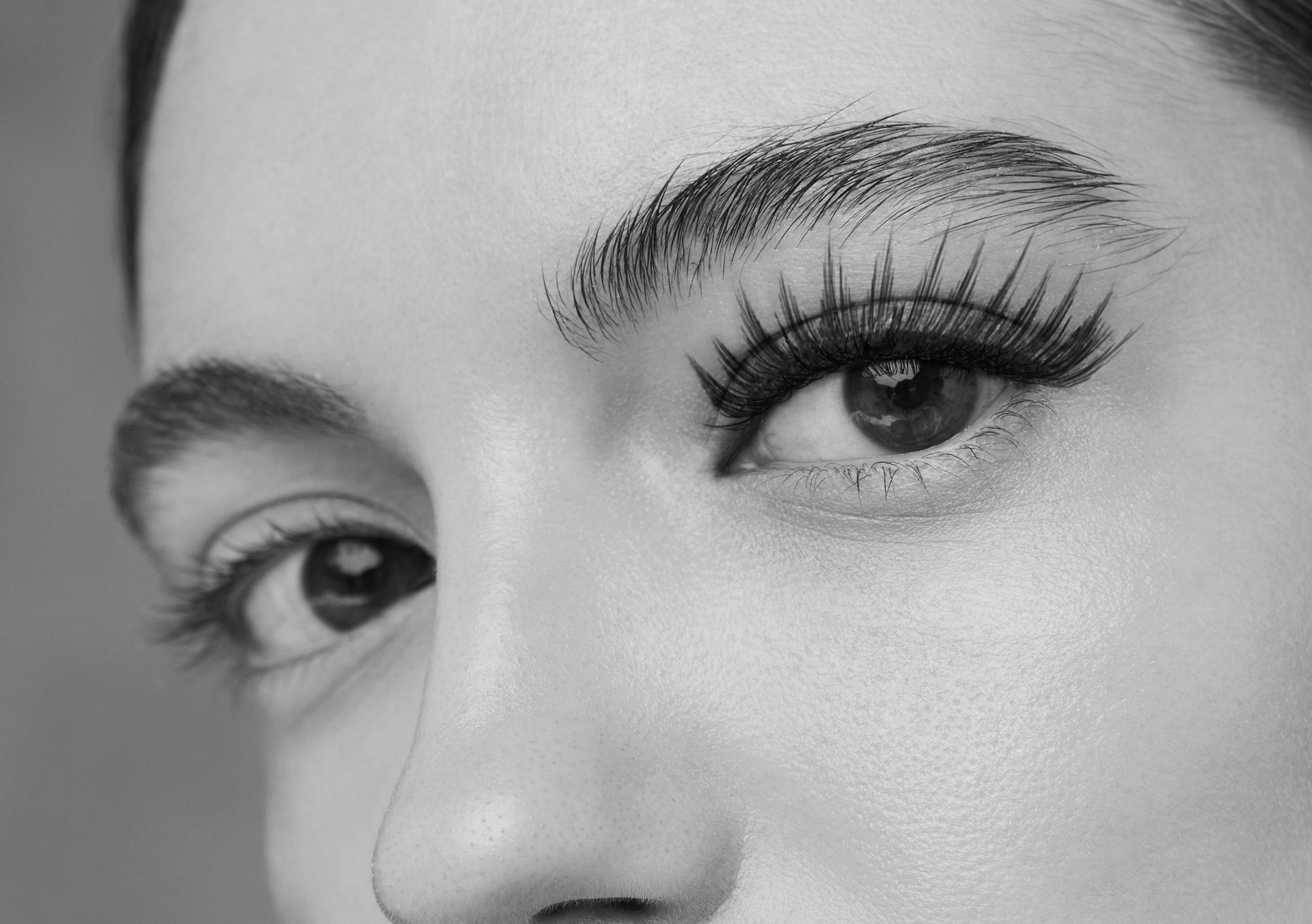 A black and white photo of a woman 's eye with long eyelashes.