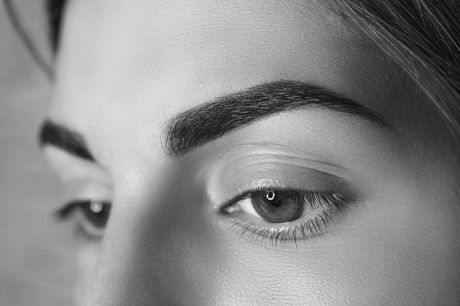 A close up of a woman 's eye in a black and white photo.