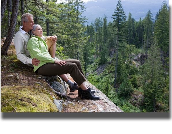 Elderly Couple Sitting on a Mountain Rock