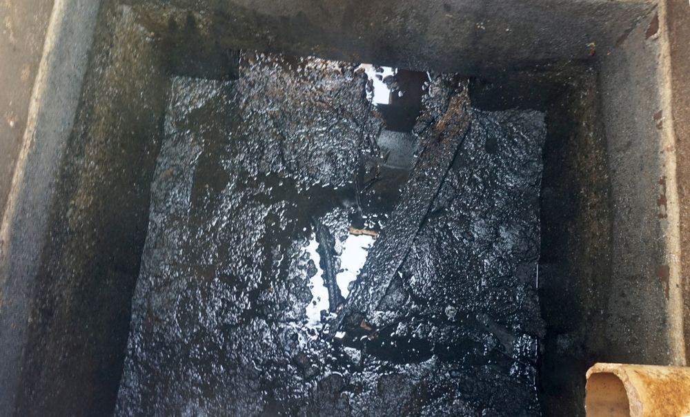 Dark, Murky Water and Debris Fill a Concrete Rectangular Container — Tyzac Group in Beerwah, QLD