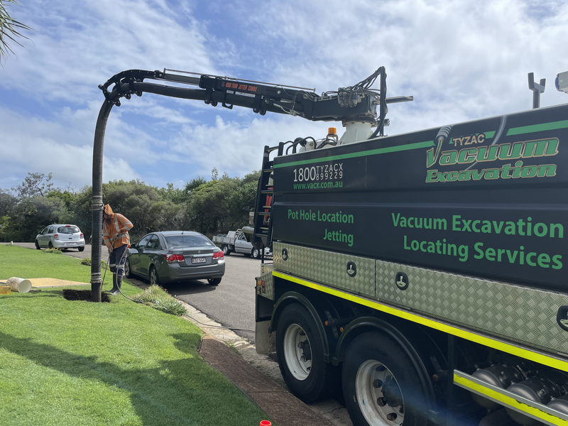 Vacuum Truck Excavating on a Road, Operator Nearby — Tyzac Group in Hervey Bay, QLD