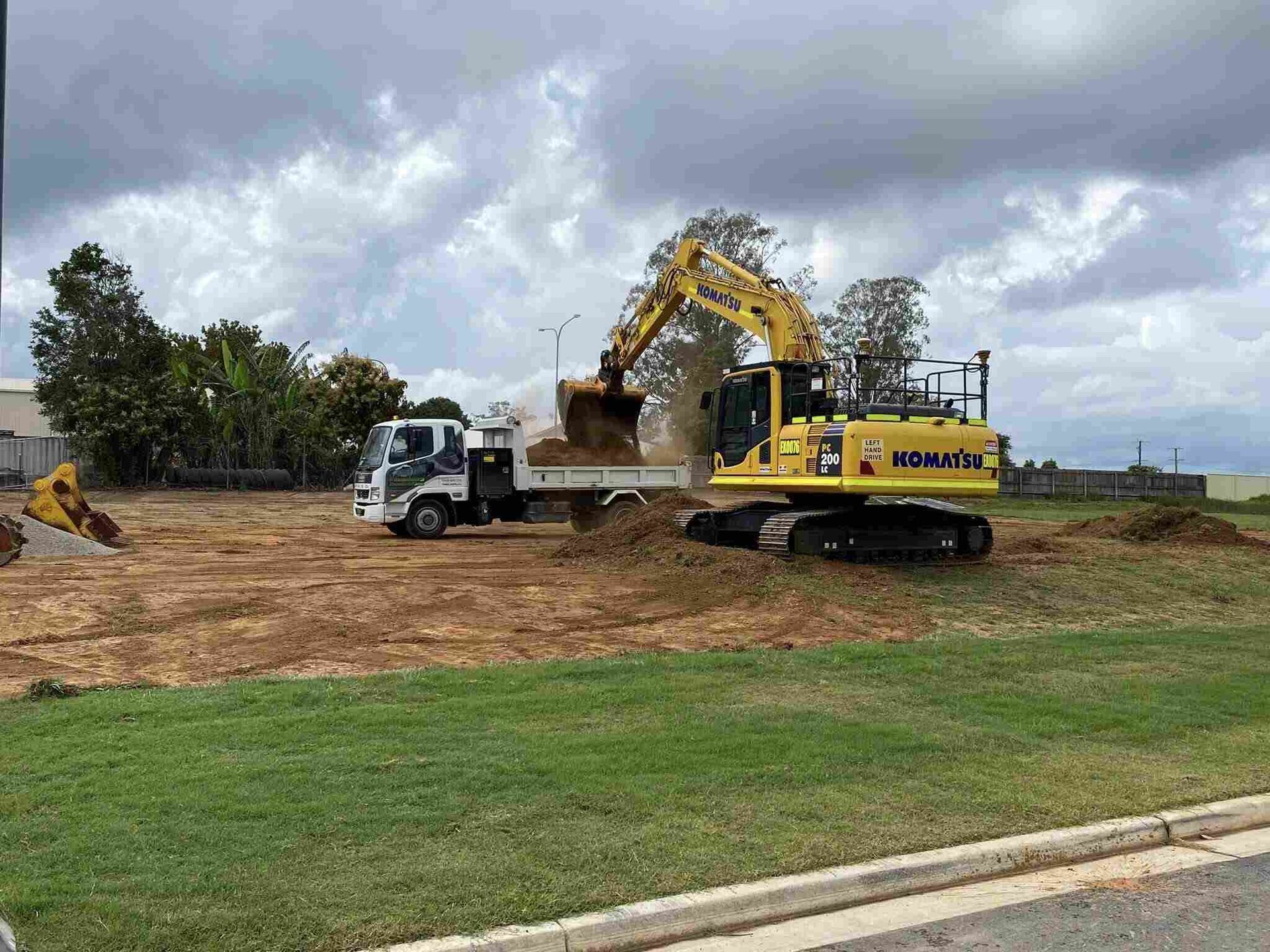 Excavator Loading Dirt Into a White Truck — Tyzac Group in Beerwah, QLD