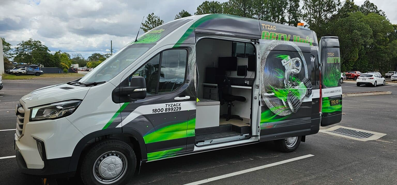 A White and Green Mobile Service Van With an Open Door in a Parking Lot — Tyzac Group in Ipswich, QLD