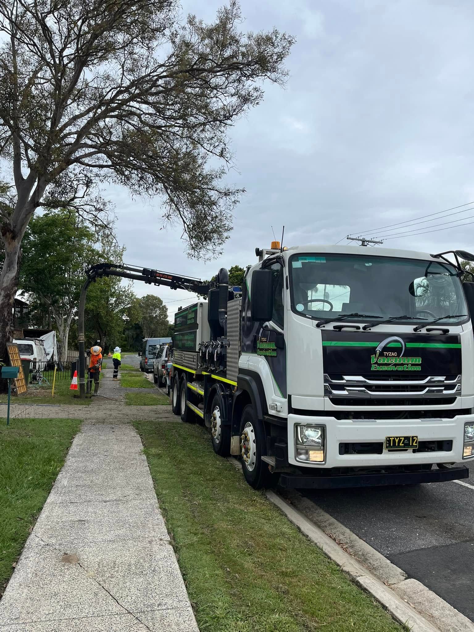 Vacuum Truck Parked With Workers In Safety Gear