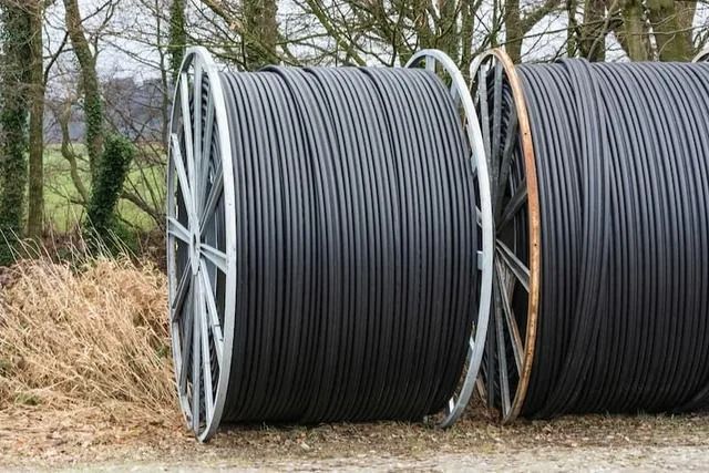 Three Large Spools of Black Cable on a Grassy Surface Near Trees — Tyzac Group in Beerwah, QLD