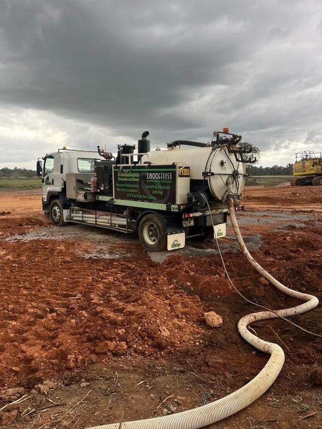 A White Vacuum Truck on a Muddy Construction Site — Tyzac Group in Beerwah, QLD