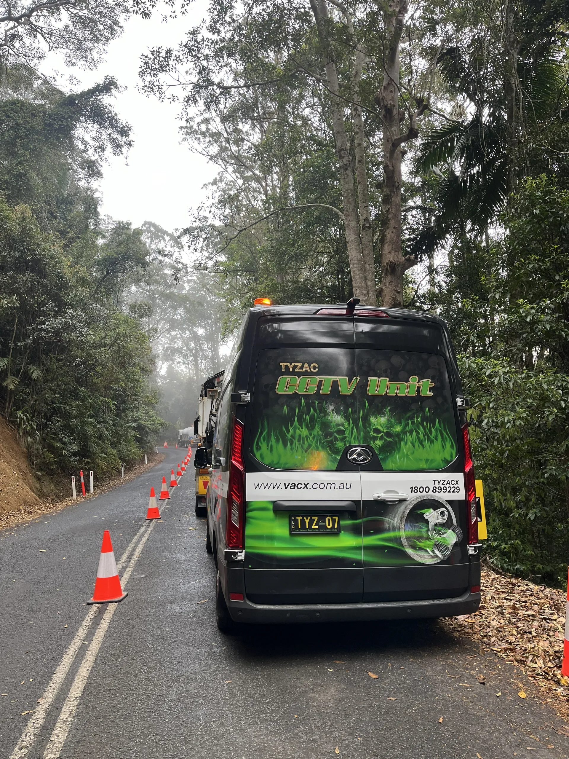 Black Van Parked on a Road Lined With Traffic Cones — Tyzac Group in Beerwah, QLD