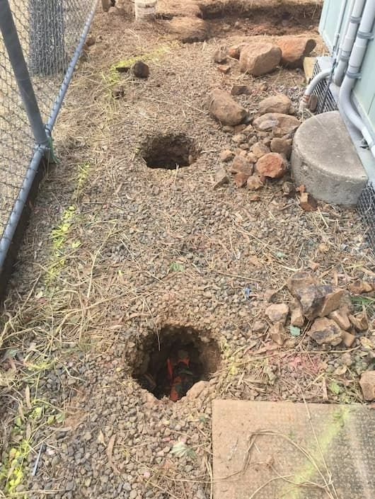 Three Holes Dug in Gravel Ground Next to a Chain-link Fence — Tyzac Group in Beerwah, QLD