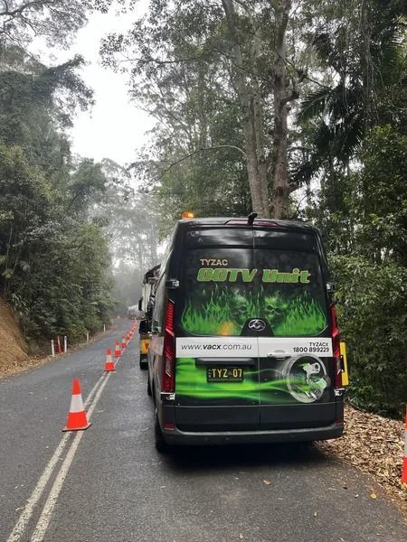 Van With Green and Black Logo Parked on a Road With Traffic Cones — Tyzac Group in Beerwah, QLD