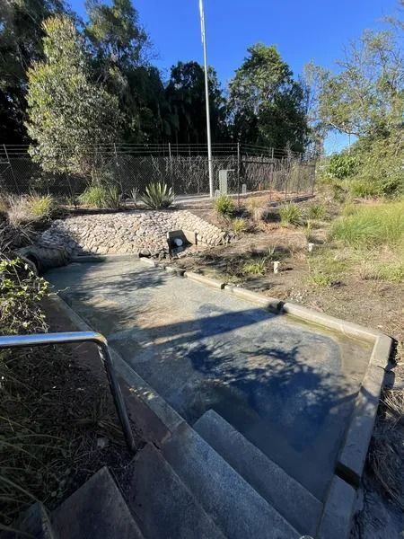 Concrete Steps Leading Down to a Gray, Paved Area With a Drain — Tyzac Group in Beerwah, QLD