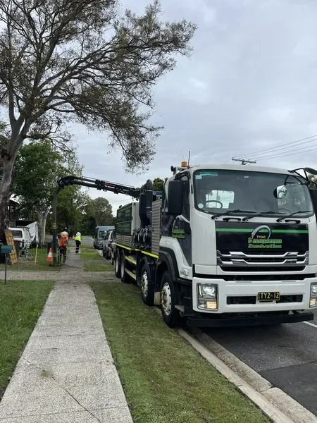 Truck With a Crane Parked on Grass Next to a Sidewalk — Tyzac Group in Beerwah, QLD