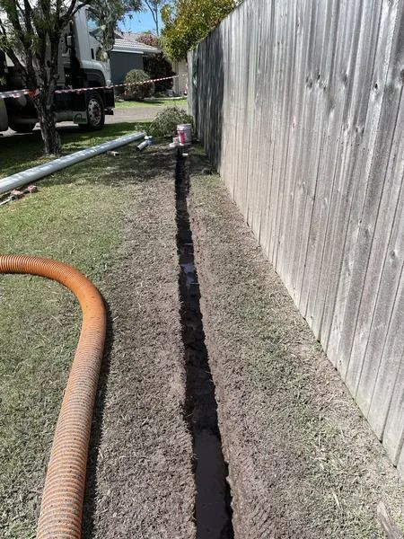 A Narrow Trench Dug in the Grass Along a Wooden Fence — Tyzac Group in Beerwah, QLD