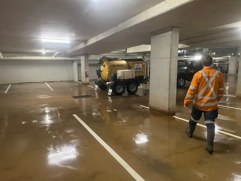 Flooded Parking Garage With Worker in Safety Vest — Tyzac Group in Beerwah, QLD
