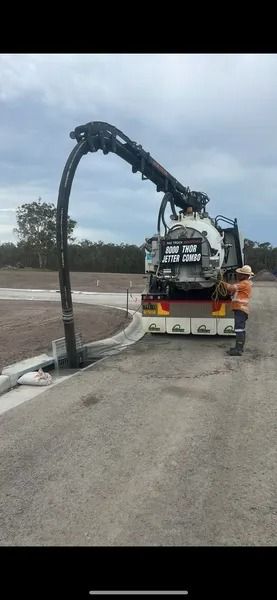 A Vacuum Truck Sucks Up Debris From a Curb-side Drain — Tyzac Group in Beerwah, QLD