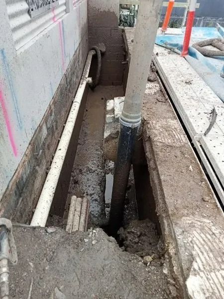 Construction Site With Exposed Pipes and a Trench in a Concrete Area — Tyzac Group in Beerwah, QLD