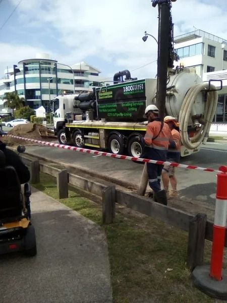 Truck With Suction Hose Connected to a Pole; Two Workers Nearby — Tyzac Group in Beerwah, QLD
