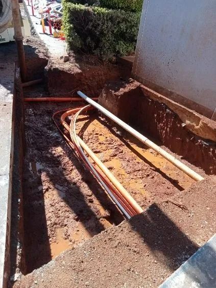 Open Trench With Orange and White Pipes Laid Inside — Tyzac Group in Beerwah, QLD