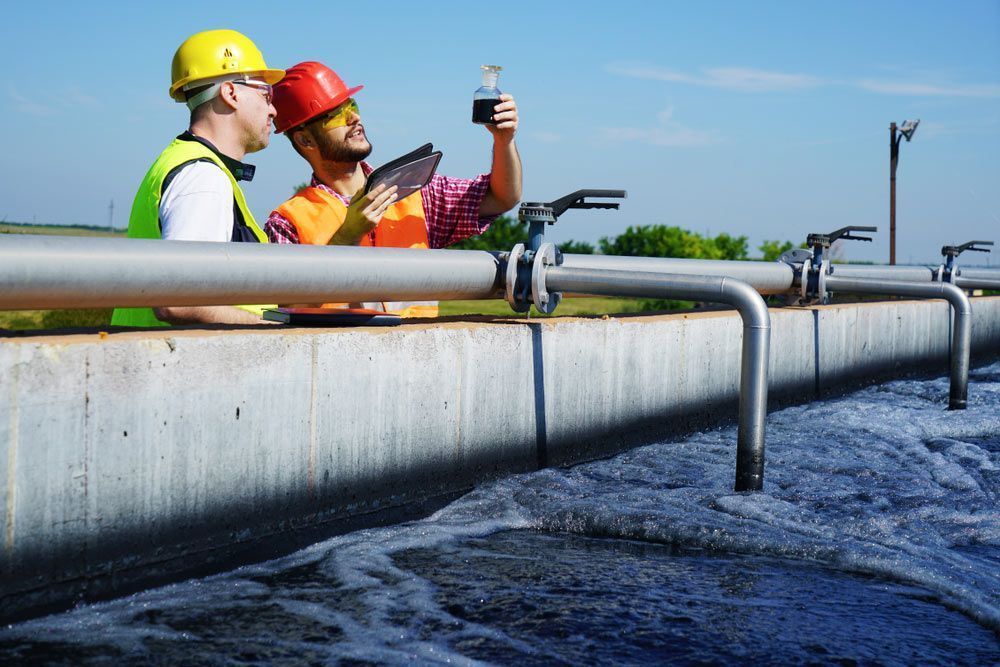 Two Men in Safety Vests Examine a Liquid Sample — Tyzac Group in Beerwah, QLD
