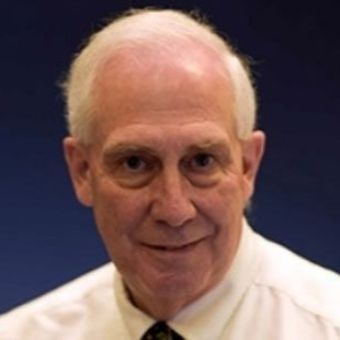 Man in a white shirt and black tie, smiling. Blue background.