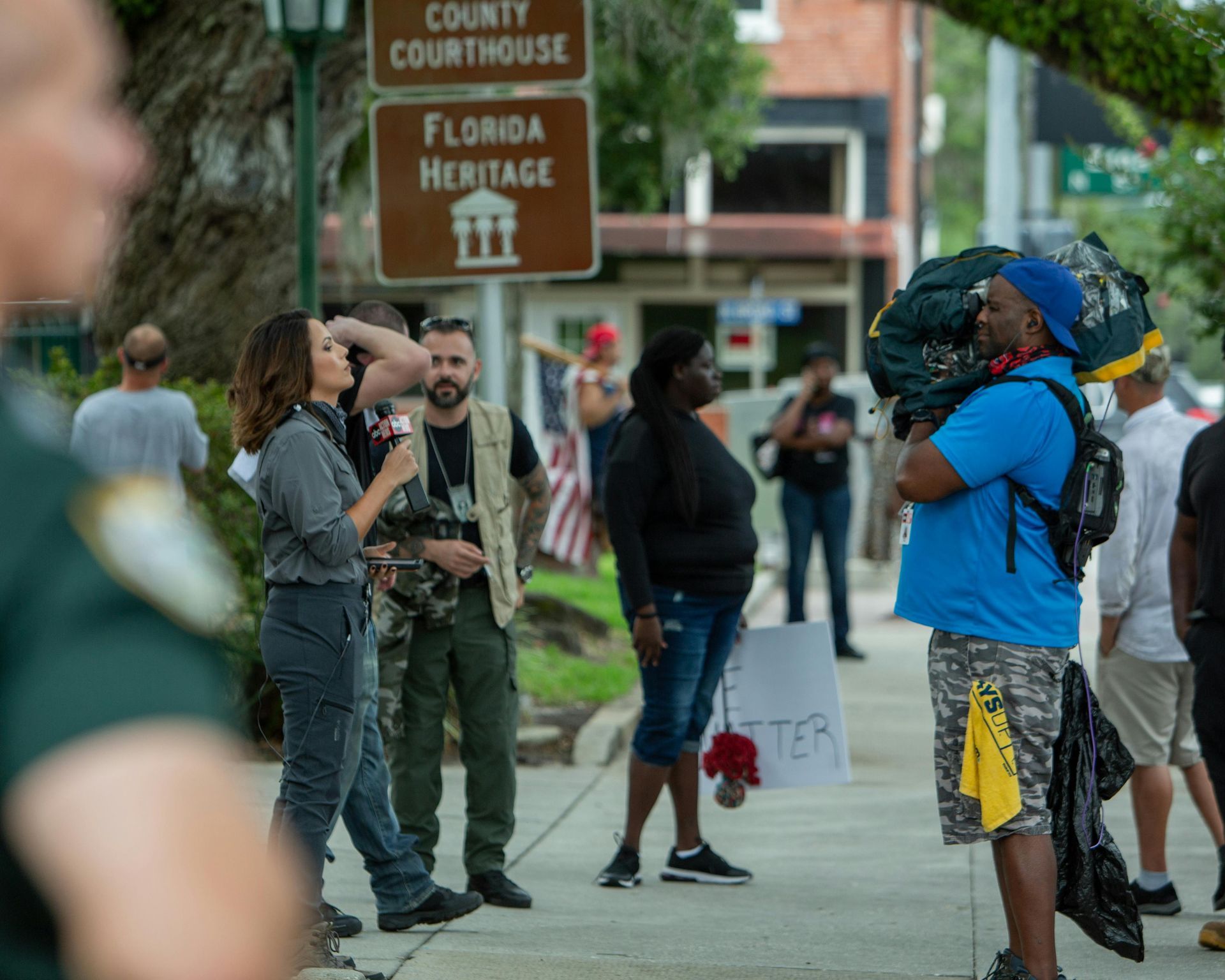 A police officer is shaking hands with a woman holding a sign that says `` i want to be heard ''.