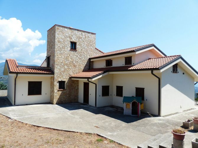 A large house with a playhouse in front of it