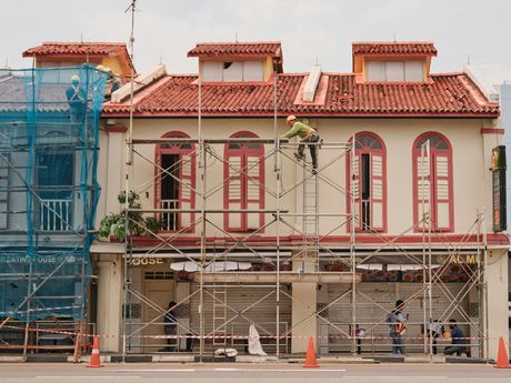 A building is being painted with scaffolding around it.
