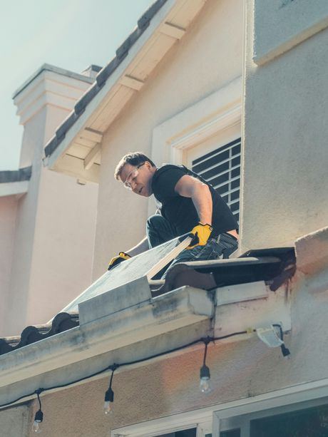 A man is working on the roof of a house.
