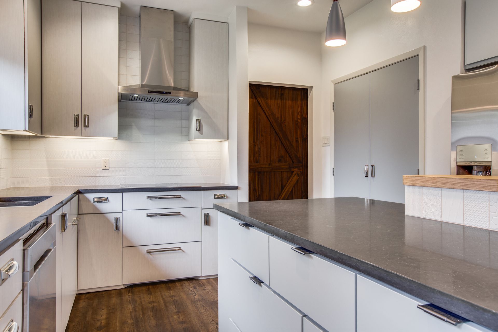 A kitchen with white cabinets and stainless steel appliances