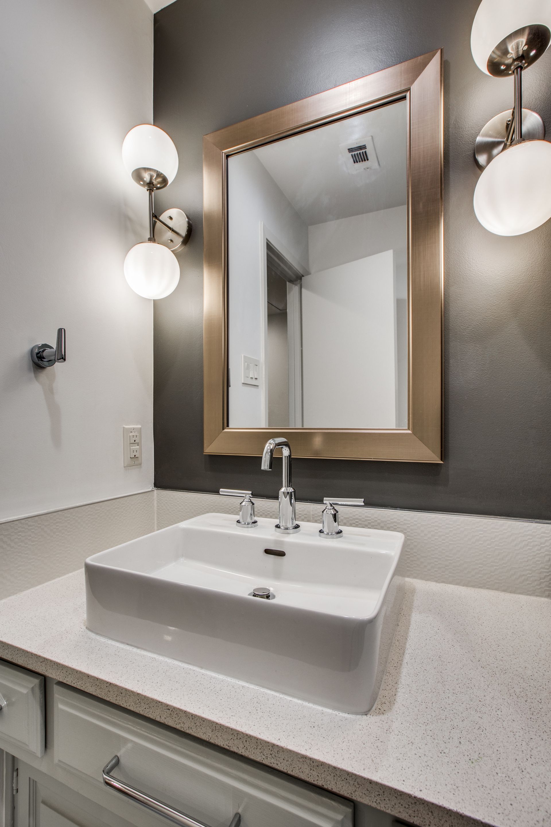 A bathroom with a sink and a mirror on the wall.