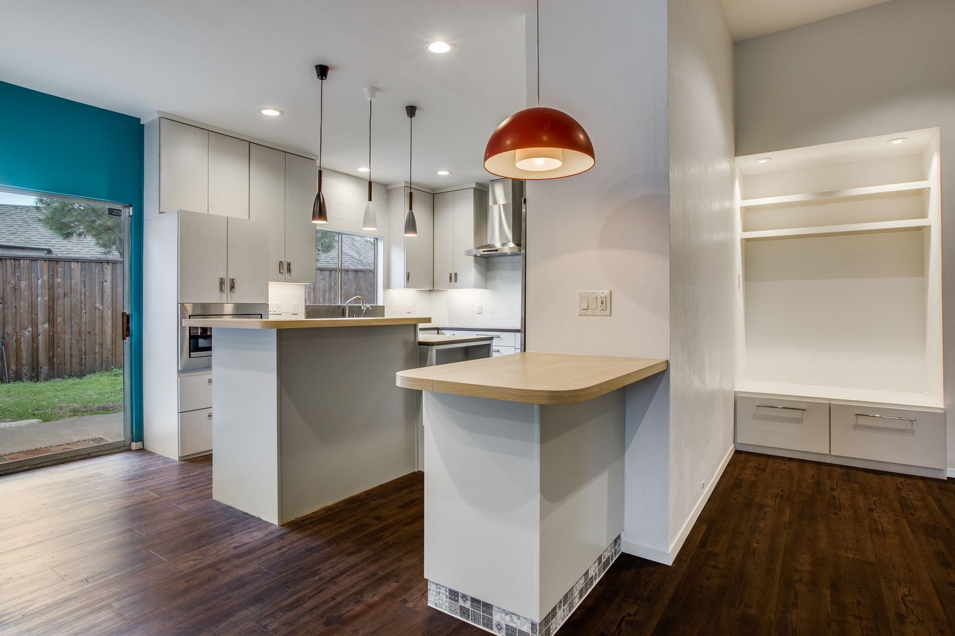 A kitchen with a large island and a red light hanging from the ceiling.
