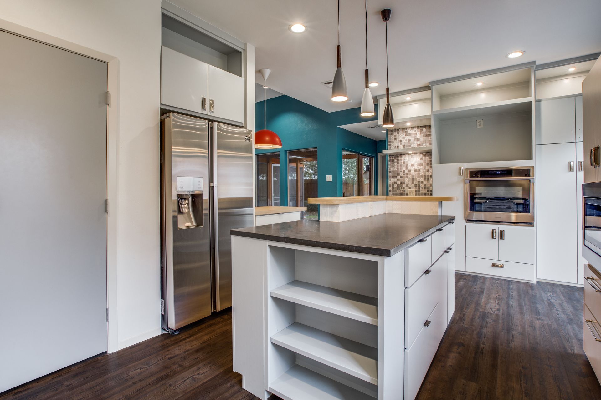 A kitchen with stainless steel appliances and a large island in the middle.