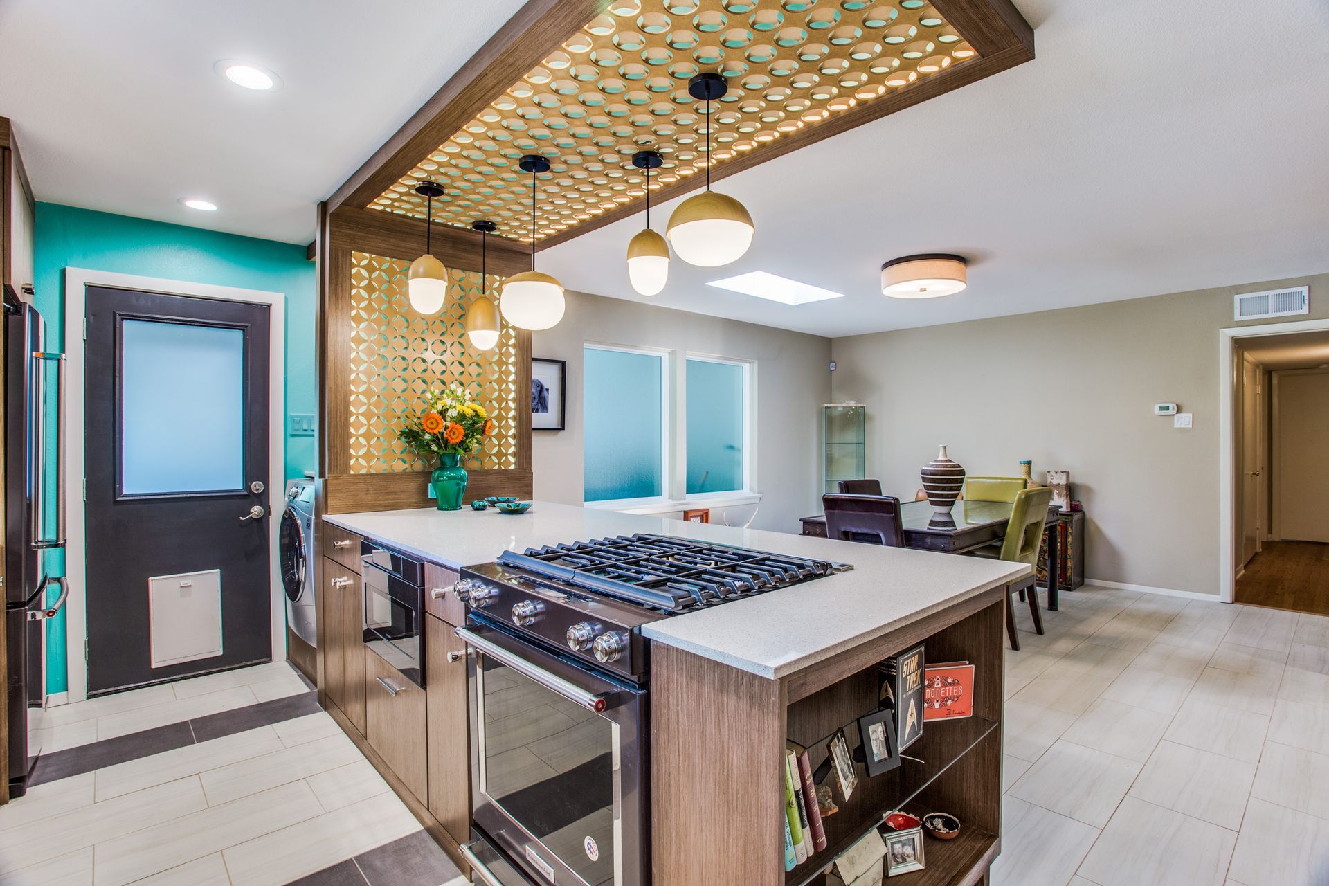 A kitchen with a large island and a stove top oven.