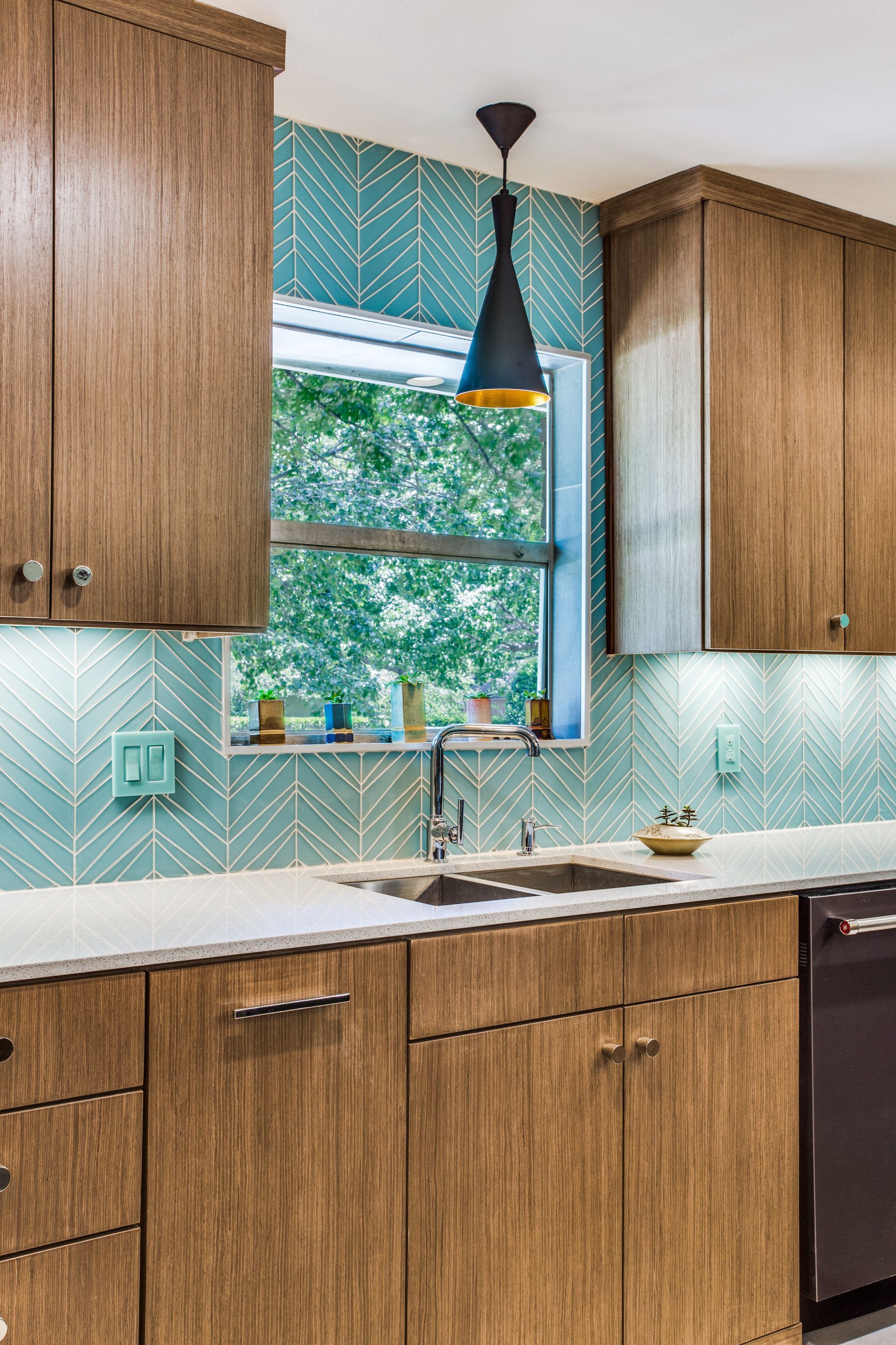 A kitchen with wooden cabinets , a sink , and a window.