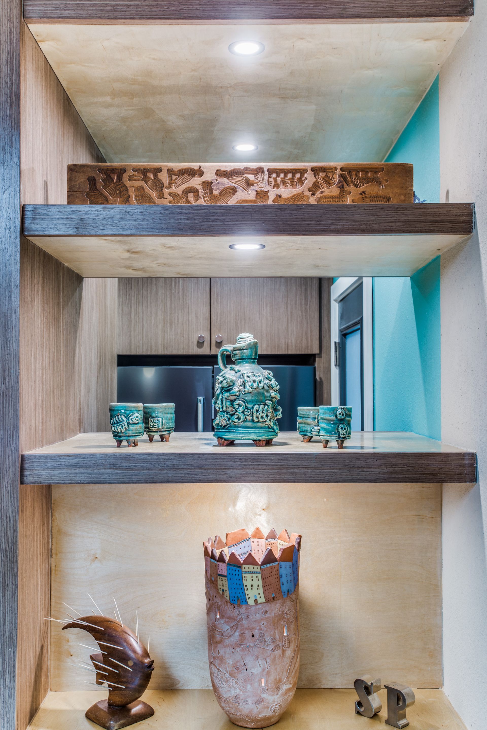 A wooden shelf with three shelves and a vase on it.