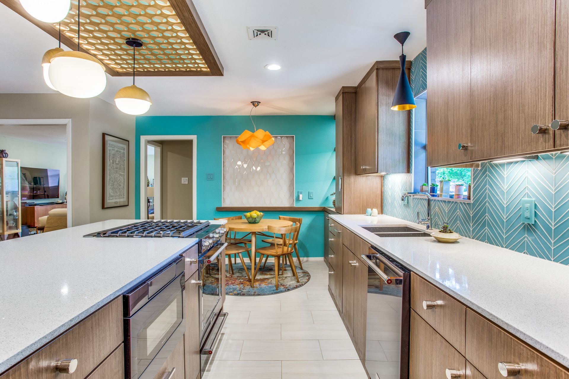 A kitchen with wooden cabinets , white counter tops , stainless steel appliances and a blue wall.