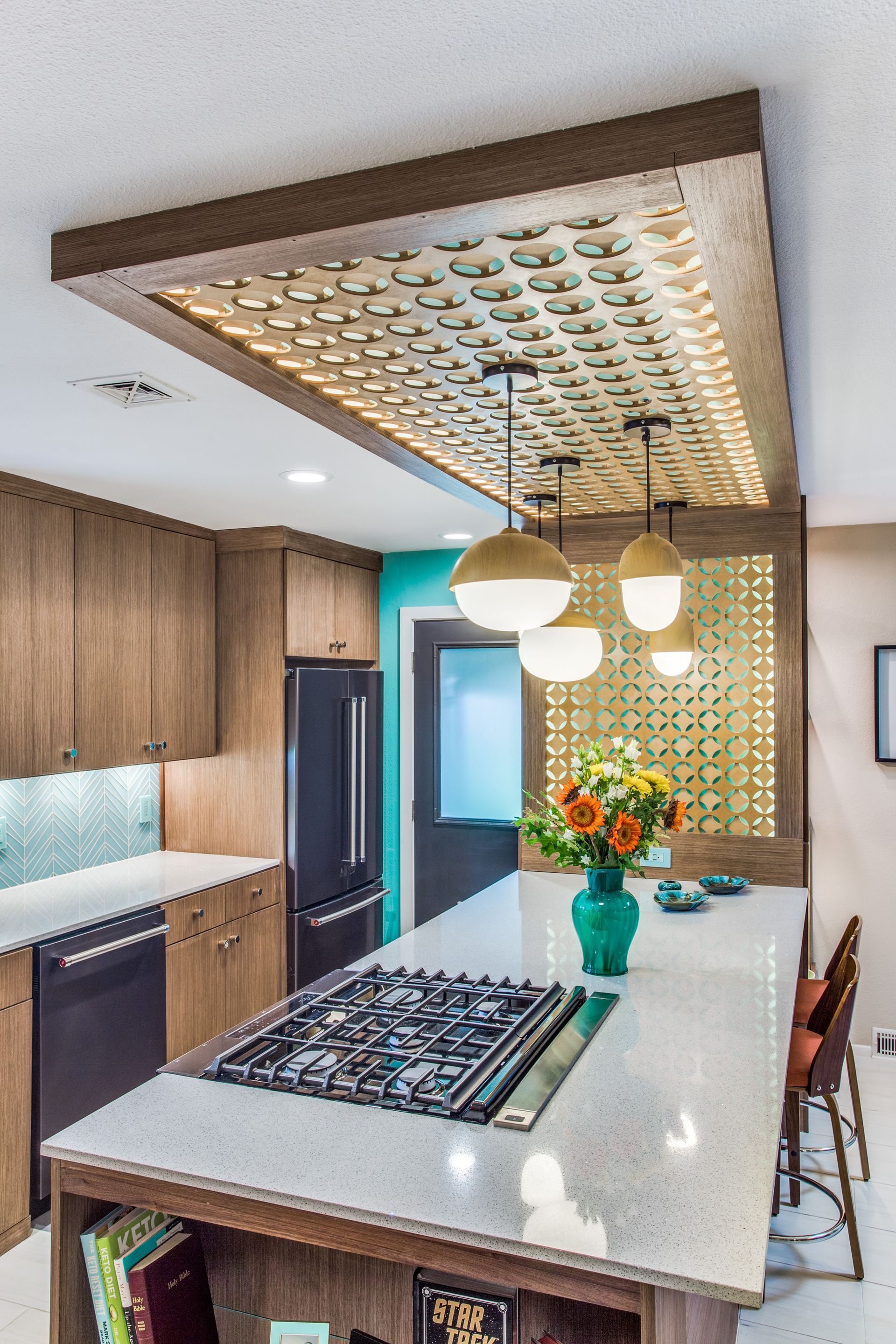 A kitchen with a large island and a stove top oven.