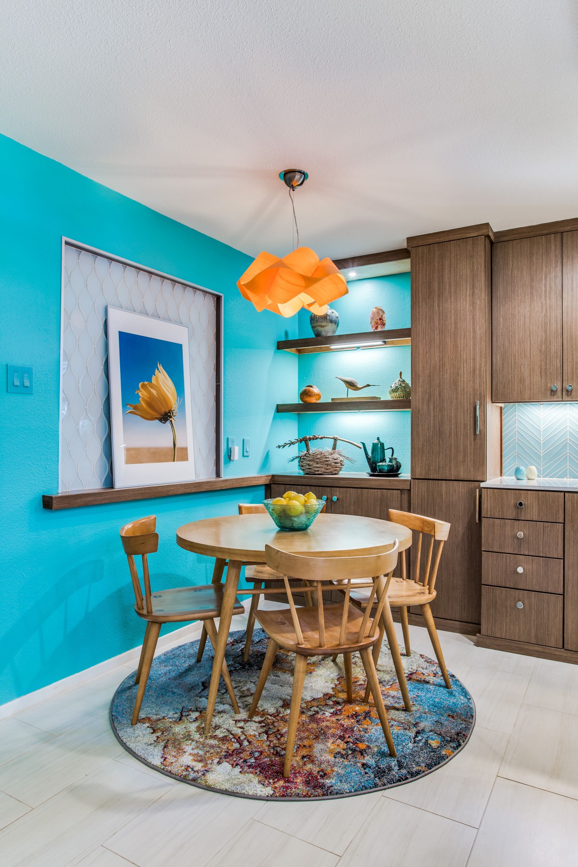 A dining room with a table and chairs and a blue wall.