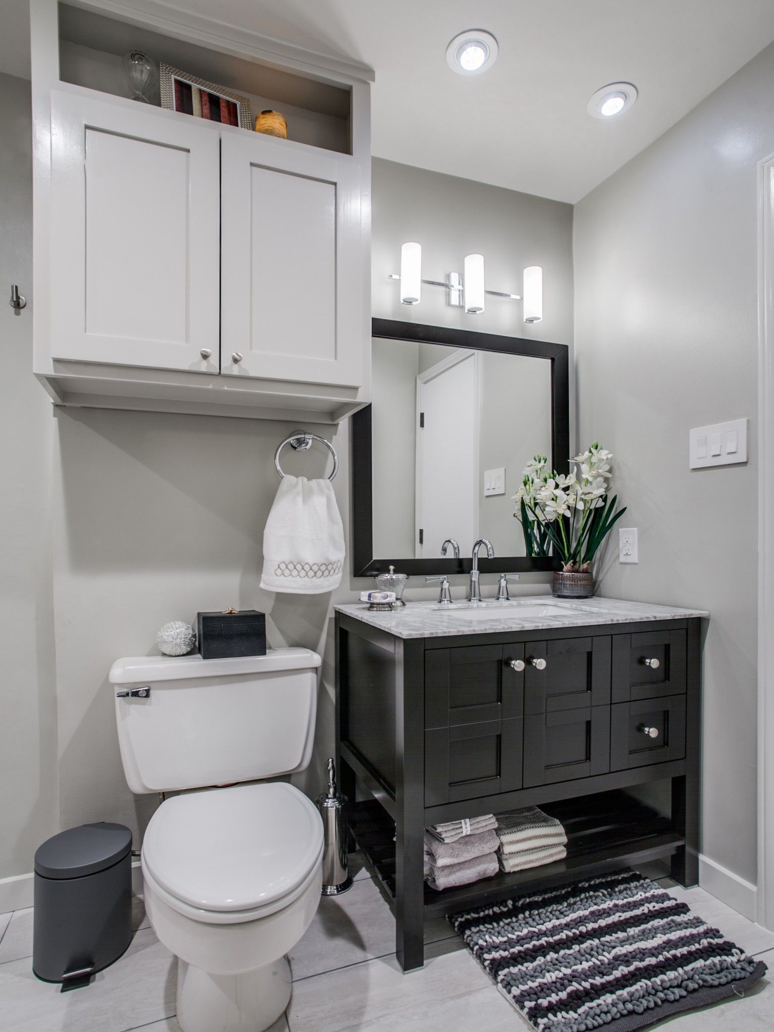 A bathroom with a toilet , sink and mirror