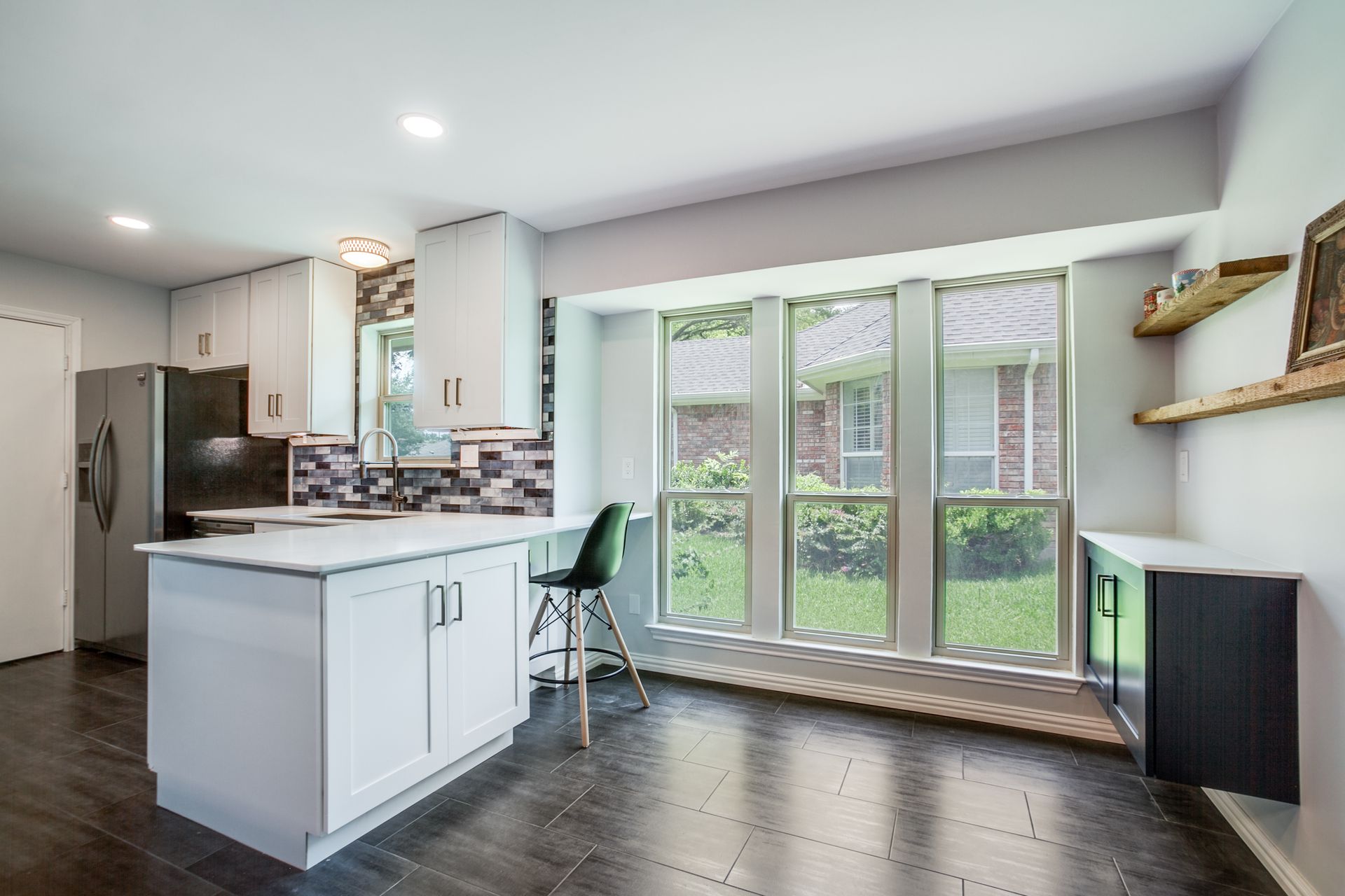 A kitchen with a large island and lots of windows.