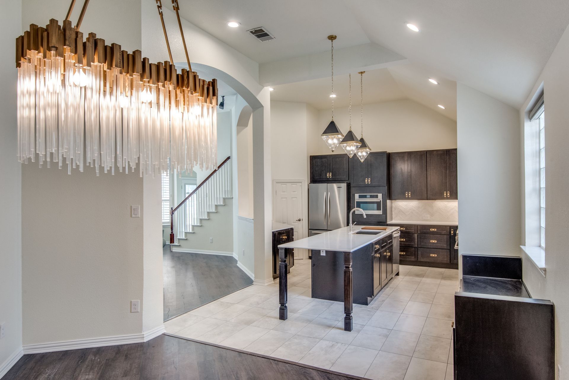 A kitchen with a large chandelier hanging from the ceiling