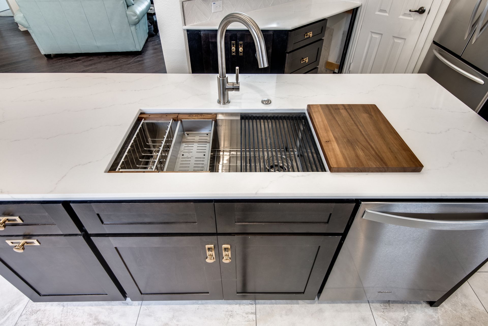 A kitchen with a stainless steel sink and a wooden cutting board.